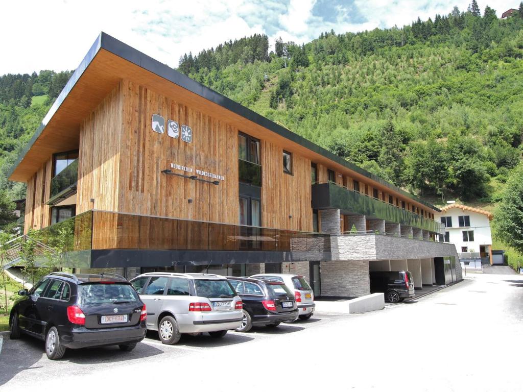 a large building with cars parked in a parking lot at Apartment Wildkogel Appartement III in Neukirchen am Großvenediger