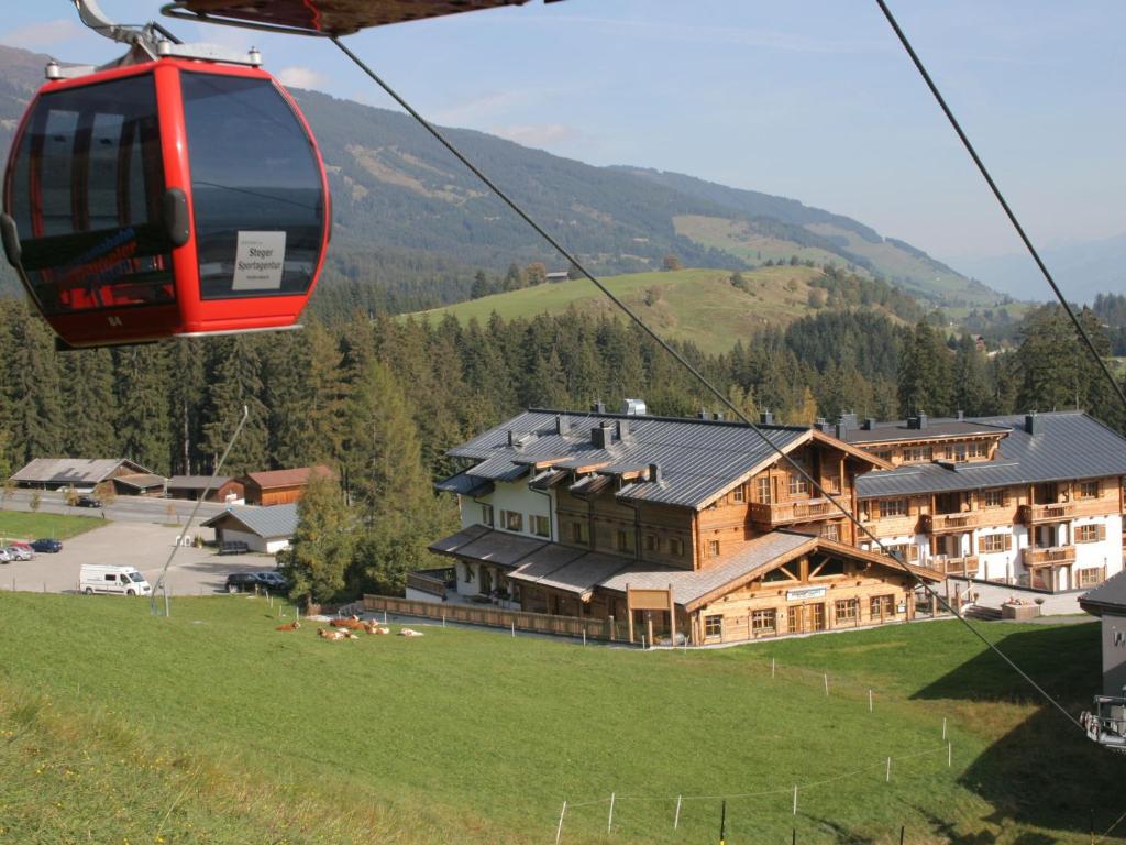 a gondola flying over a house in a mountain at Holiday home with snow covered views in Hollersbach im Pinzgau
