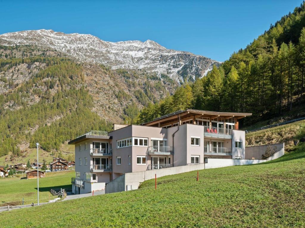 a building on a hill with a mountain in the background at Cosy flat in Zweiselstein with Garden in Sölden