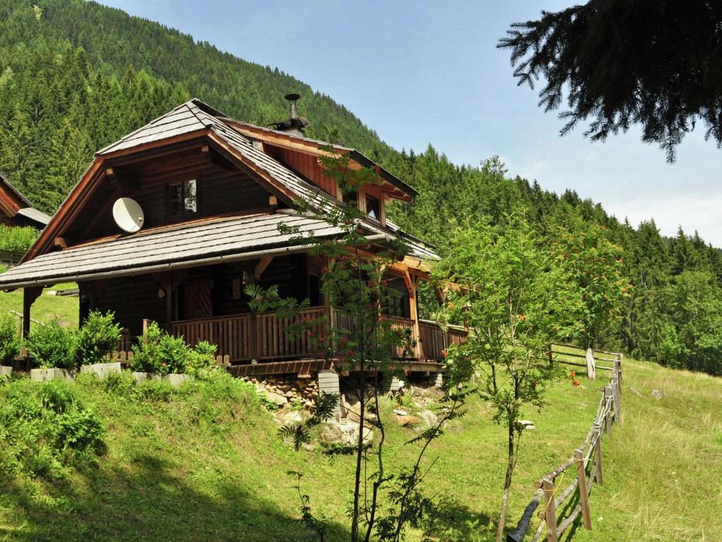 a wooden house on a hill with a mountain at Inviting Chalet in Kolbnitz Teuchl with Garden and Terrace in Penk