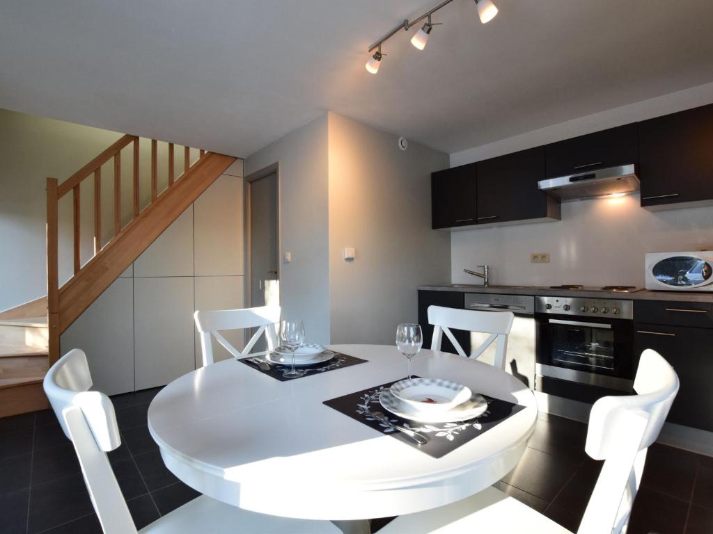 a kitchen and dining room with a white table and chairs at Modern Holiday Home in Florenville with Garden in Chassepierre