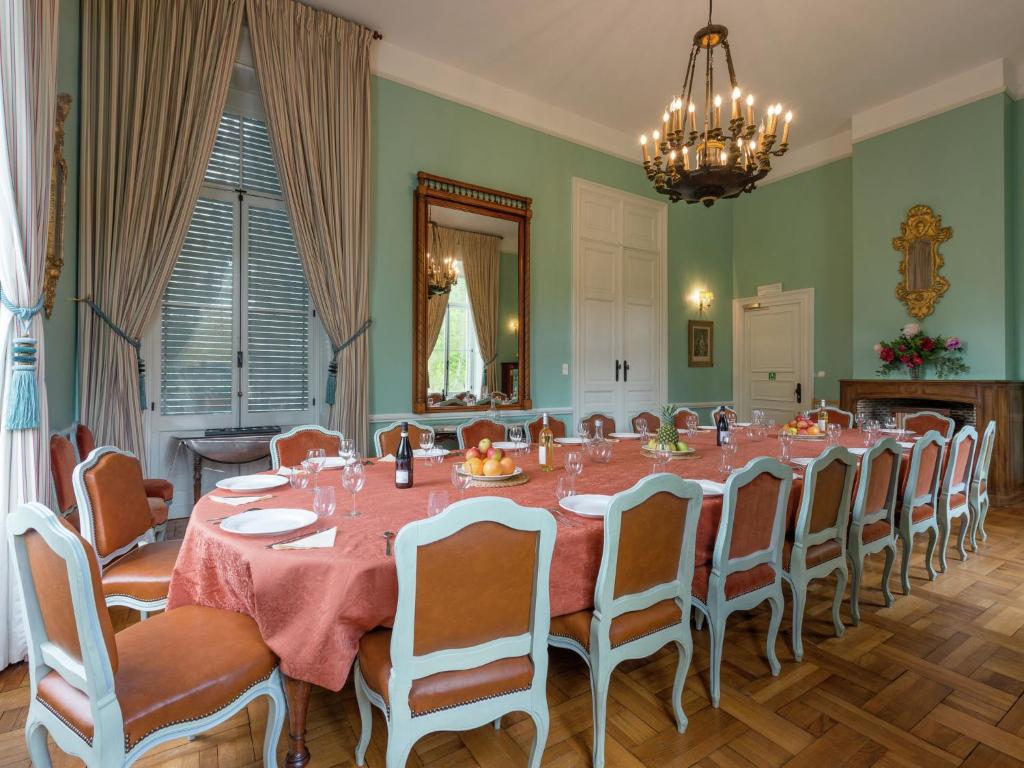 uma sala de jantar com uma mesa longa e cadeiras em Beautiful manor house in a park near Rochefort em Forrières