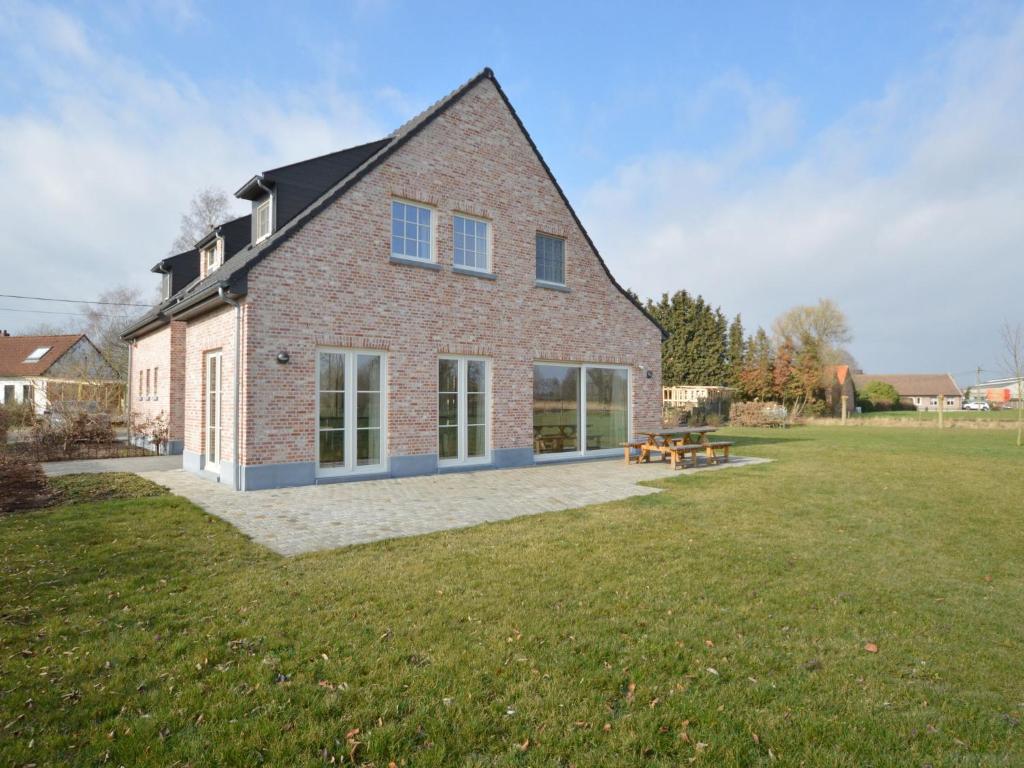 ein großes Backsteinhaus mit einem Picknicktisch im Hof in der Unterkunft Soothing Holiday Home with Recreation Room in Sint-Amands