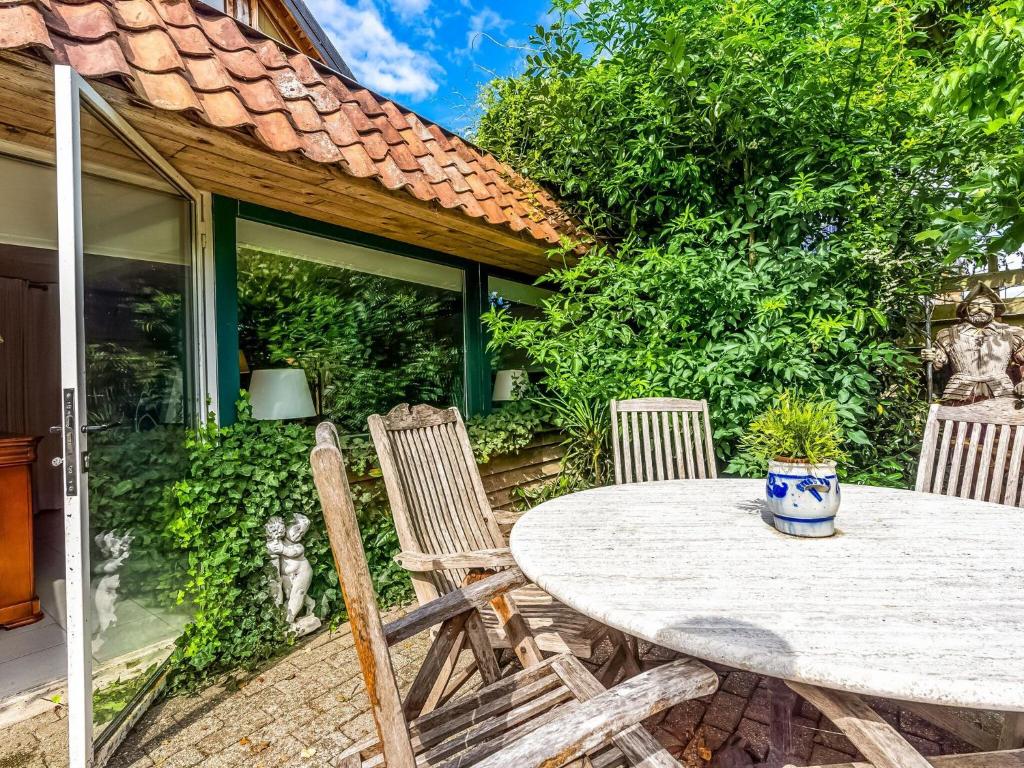 een tafel en stoelen op de patio van een huis bij Holiday Home with Terrace Garden Parking in Uikhoven