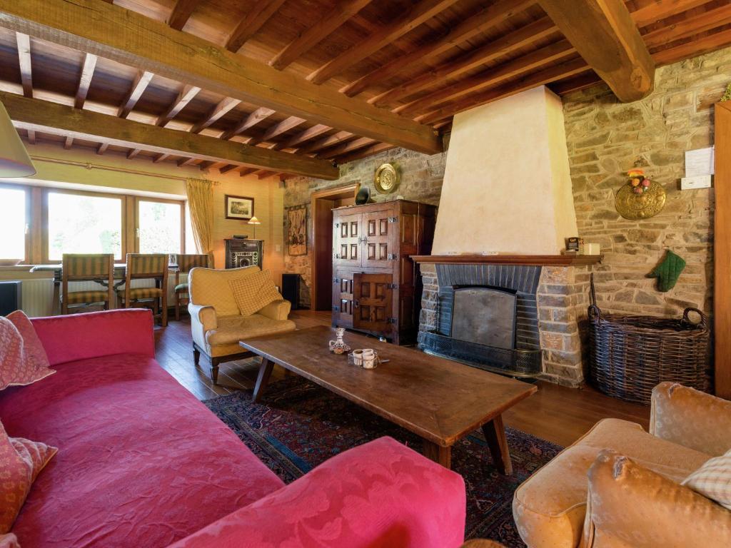 a living room with a couch and a fireplace at Cosy holiday house near La Roche in Rendeux