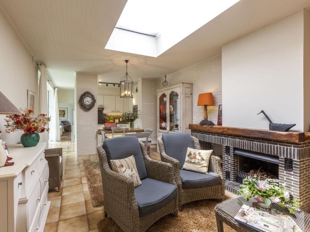 a living room with chairs and a fireplace at Modern Holiday Home in Zingem with Garden in Zingem