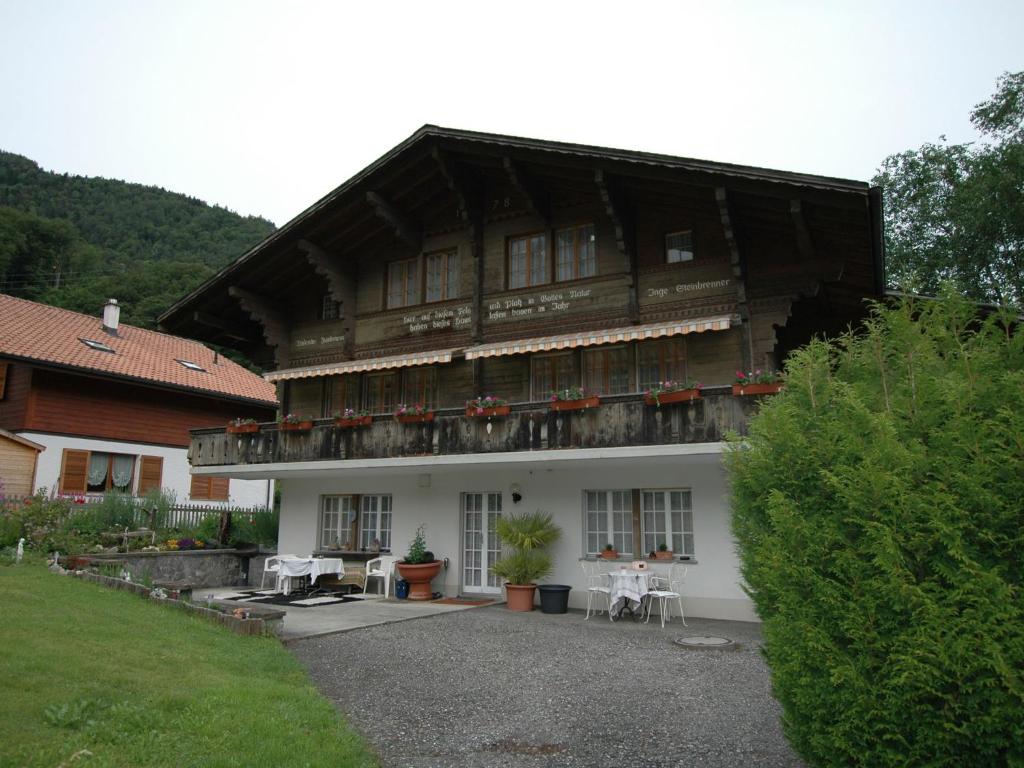 Una gran casa de madera con ventanas y plantas. en Pristine home in a charming village large grassy sunbathing area view of the M nch and Jungfrau, en Wilderswil