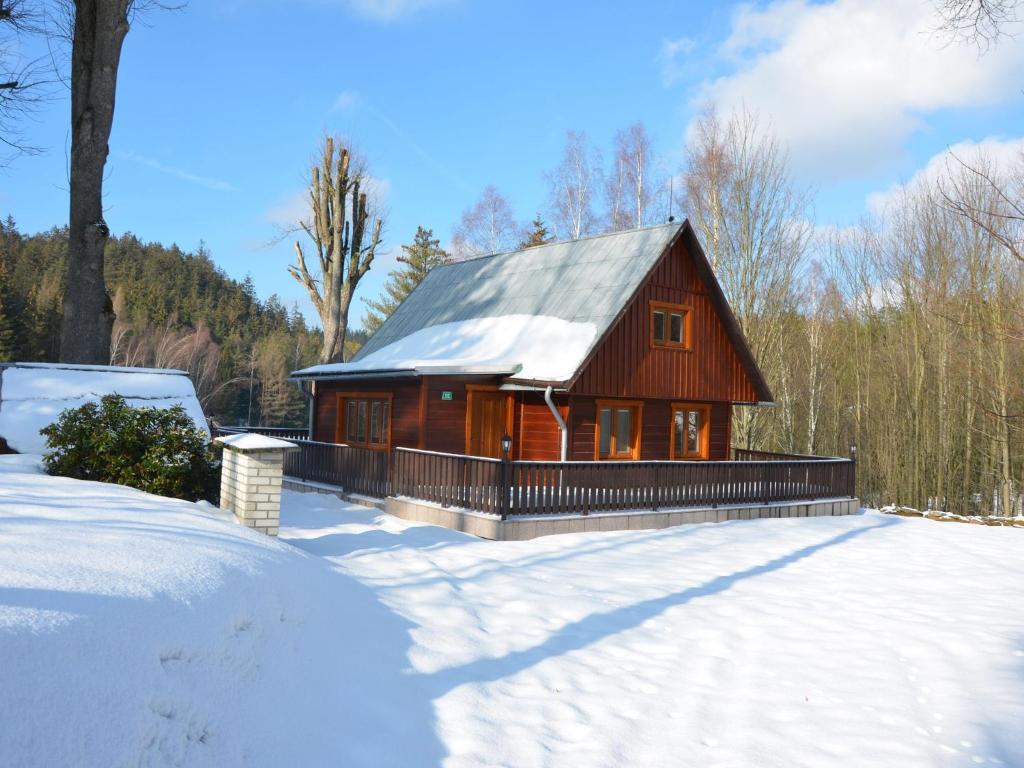 mały drewniany dom z śniegiem na ziemi w obiekcie Chalet in Kyjov near Kyjovská Dam w mieście Kyjov
