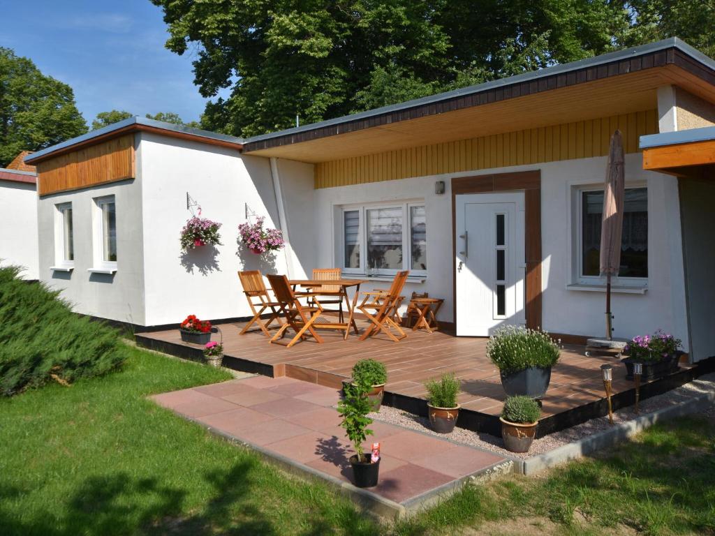 a patio with a table and chairs in front of a house at Pleasing Bungalow in Boiensdorf with Fenced Terrace in Boiensdorf