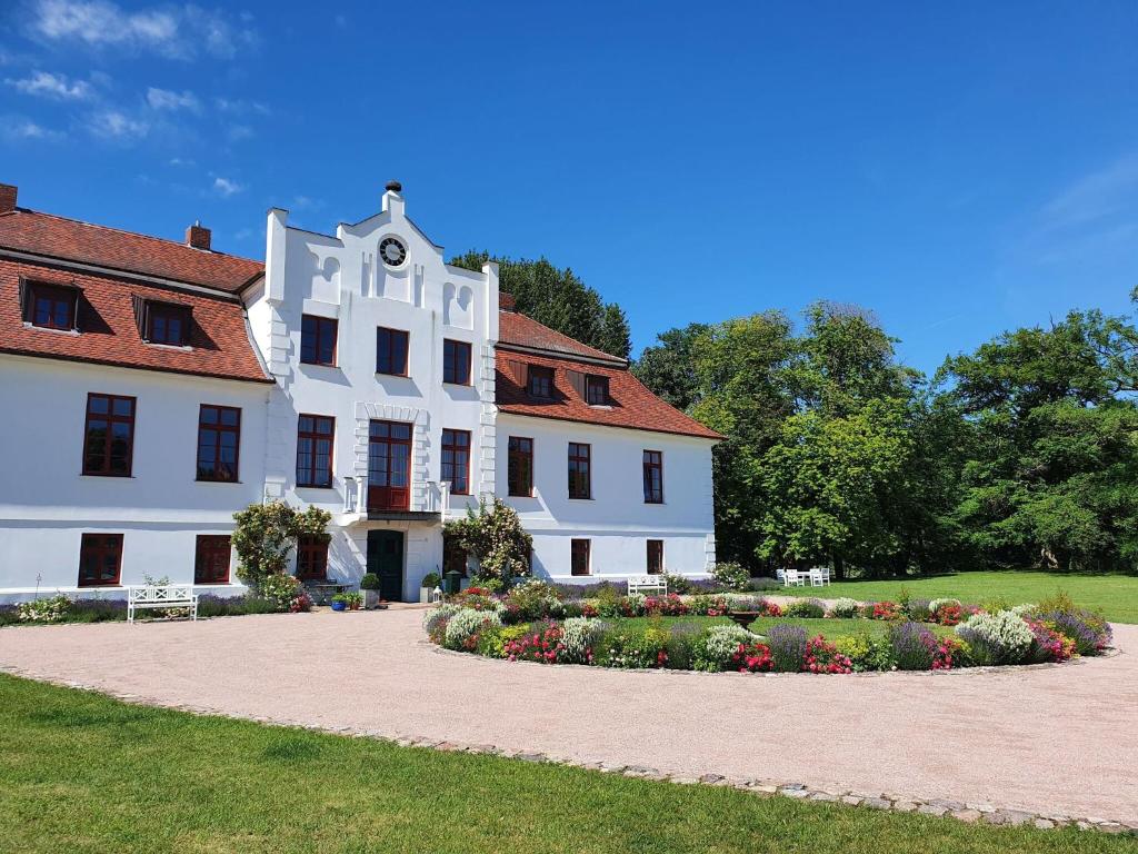 GerdshagenにあるBeautiful Apartment in Gerdshagen near Baltic Sea Coastの白い大きな建物(正面に庭園あり)