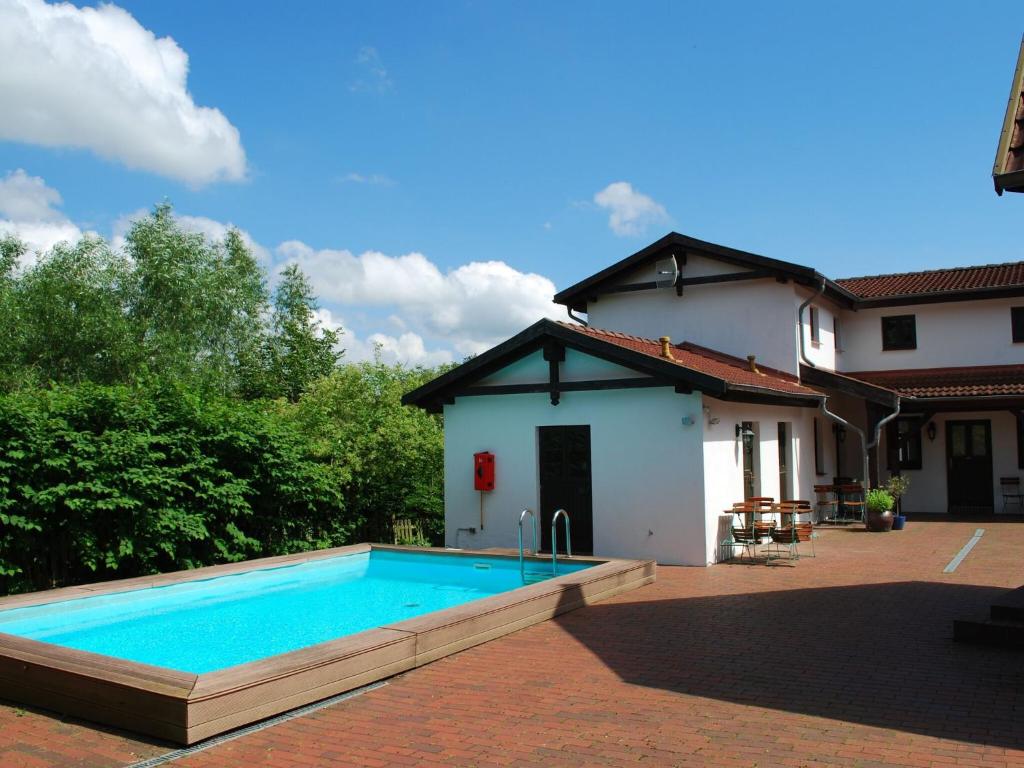 a swimming pool in front of a house at Spacious Apartment in Dargun Mecklenburg with Swimming Pool in Barlin