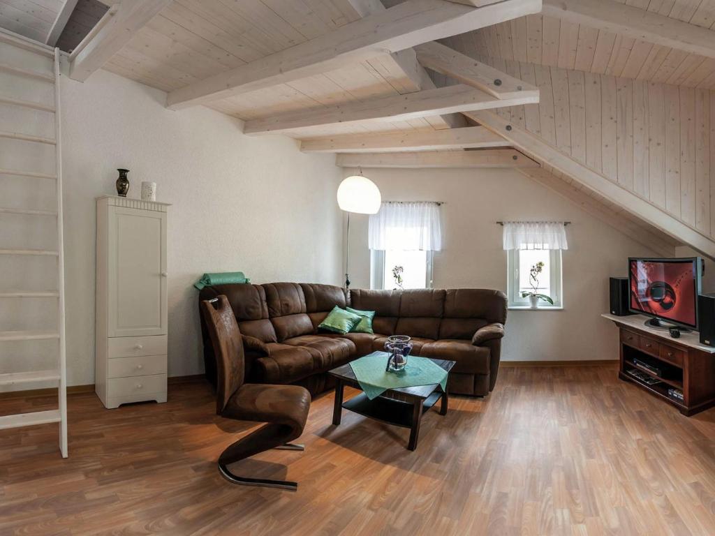 a living room with a leather couch and a tv at Ruhige Ferienwohnung mit Parkplatz in Thale in Thale