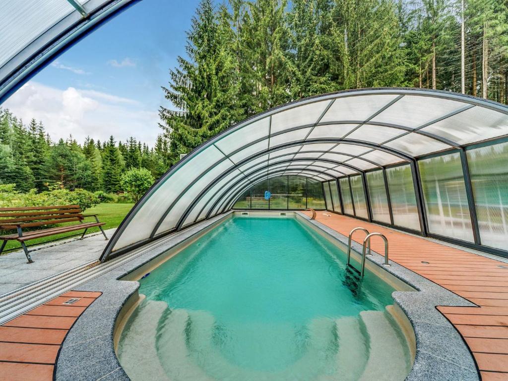 Holiday home with swimming pool in J gersgr n في Bad Reiboldsgrün: مسبح في مبنى فيه نفق