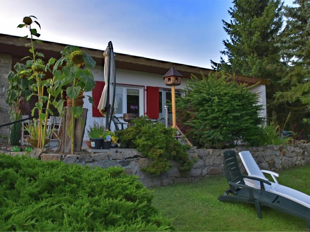 a house with a bench and an umbrella in the yard at Cozy Holiday Home in G ntersberge with Garden in Güntersberge