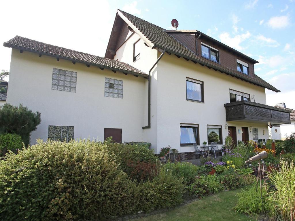 uma grande casa branca com um jardim em frente em Apartment near the ski area in Diemelsee em Diemelsee
