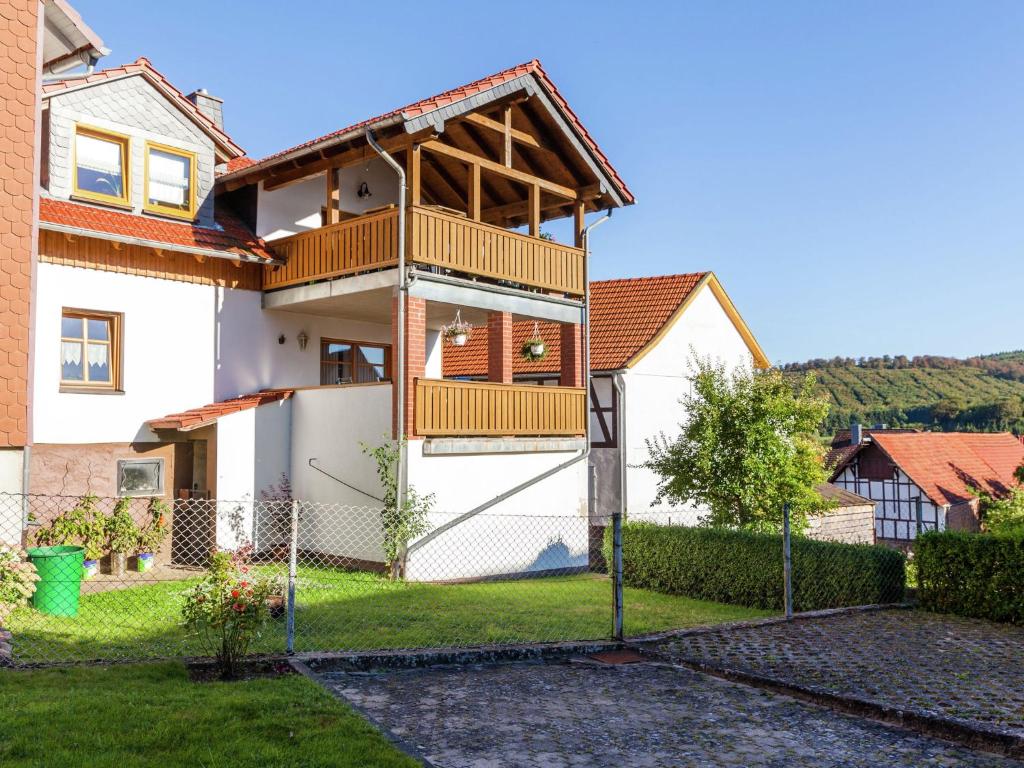 uma casa com uma varanda e uma cerca em Flat in Densberg with nearby forest em Densberg