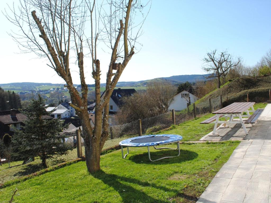 a picnic table in the grass next to a tree at An attractive apartment in Gerolstein in Gerolstein