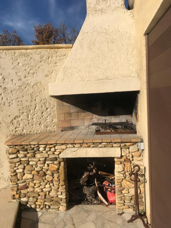 a brick oven with a fire inside of it at CHAMBRES D&#39;HÔTES CLIMATISÉES avec CUISINE d&#39;ÉTÉ &quot;VILLA GOUR du PEYROL&quot; in Buisson