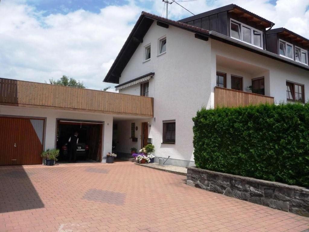 a large white house with a brick driveway at Apartment in Dietmannsried near the forest in Dietmannsried