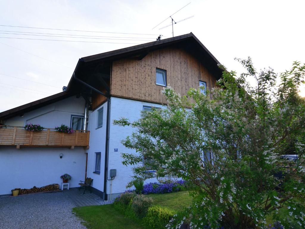 a large white house with a gambrel roof at Apartment in Lechbruck Bavaria with garden in Lechbruck