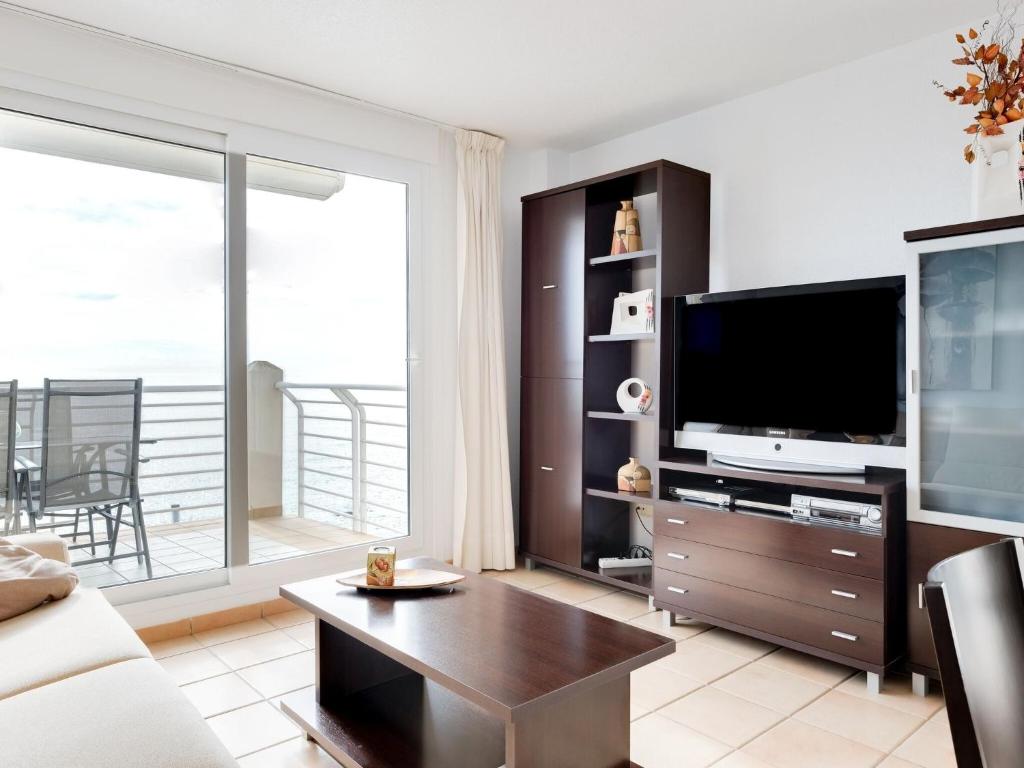 uma sala de estar com televisão e uma grande janela em Quaint Apartment close to the Seabeach em Vinarós
