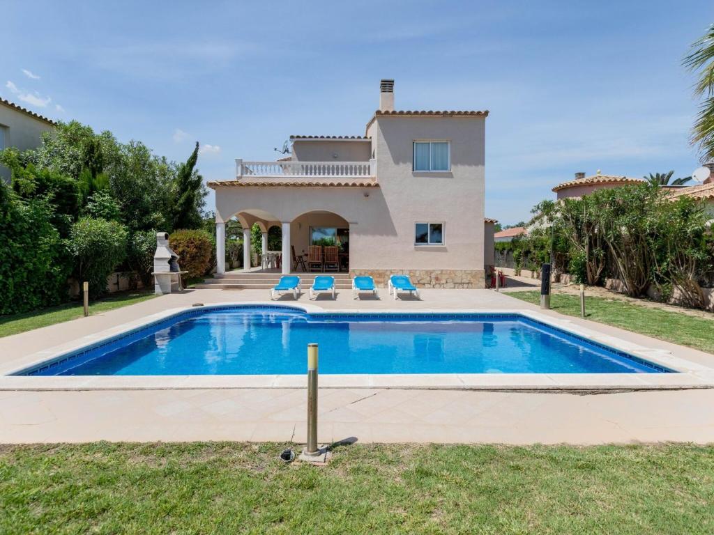 una villa con piscina di fronte a una casa di Belvilla by OYO Nautic Palmera a Sant Pere Pescador