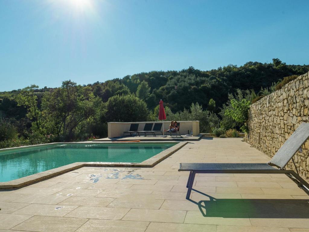 ビュイ・レ・バロニにあるBeautiful villa with panoramic view, in the hills of the Mont Ventouxの石壁の隣にベンチ付きのスイミングプール