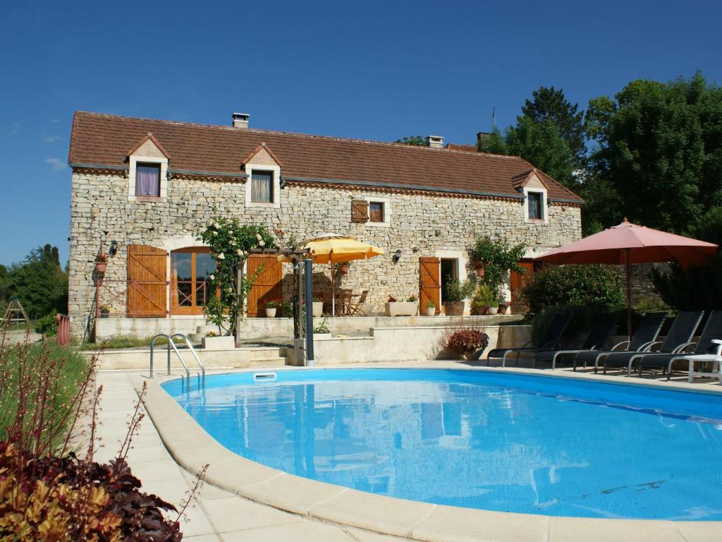 una grande piscina di fronte a una casa di Charming holiday home with pool a Lavercantière