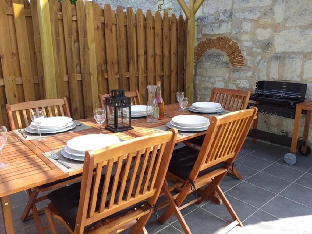 een houten tafel met stoelen en borden erop bij Beautiful villa in central France in La Chapelle-Blanche-Saint-Martin