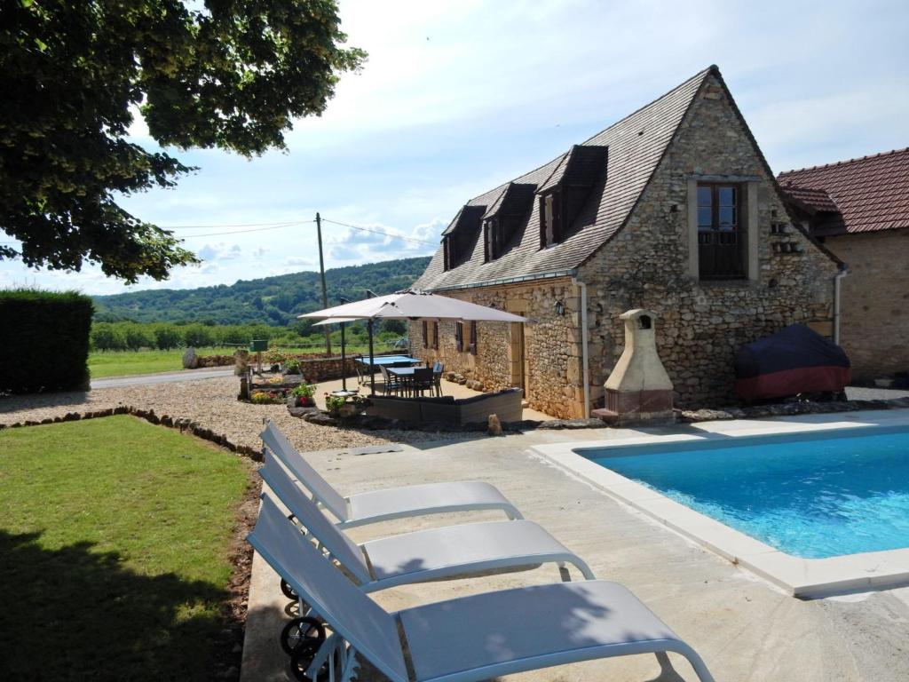 uma vista exterior de uma casa de pedra com uma piscina em Cozy Holiday Home in Saint L on sur em Sergeac