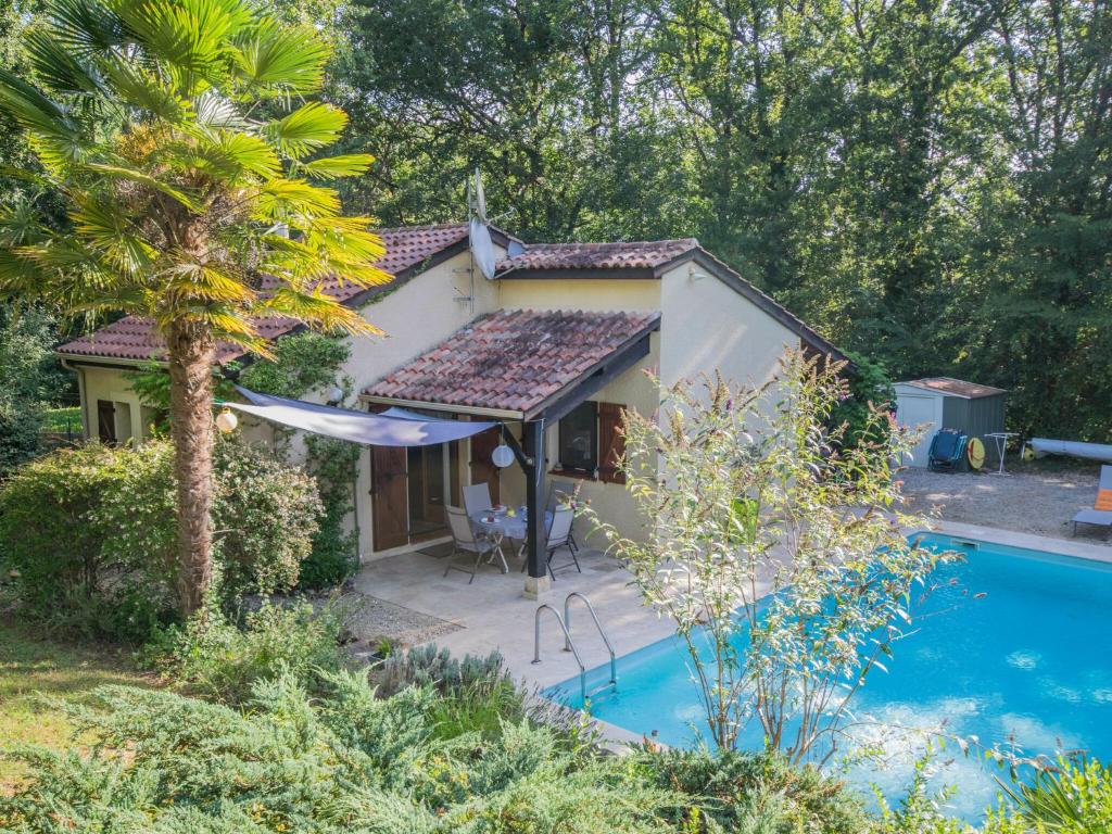 uma pequena casa com uma piscina em frente em Quiet holiday home with large pool em Saint-Martin-le-Redon
