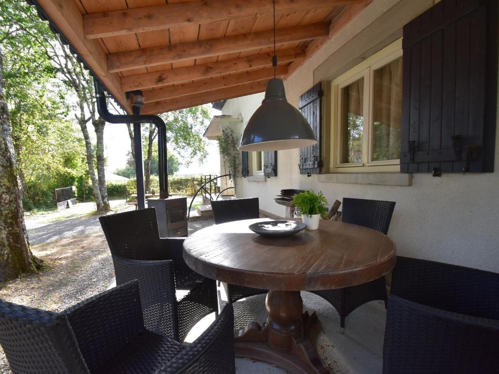 uma mesa de madeira e cadeiras num pátio em Modern holiday home with lovely garden em Saint-Honoré-les-Bains