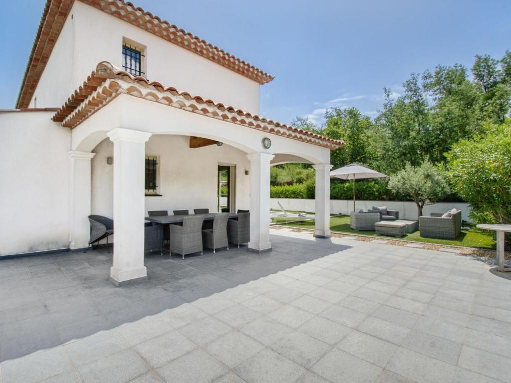 a patio in front of a white house at Cosy villa with private pool in Emponse