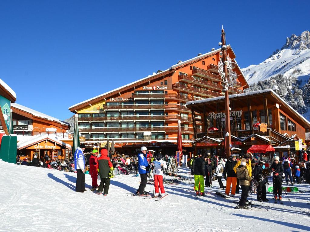 un groupe de personnes debout dans la neige devant un lodge de ski dans l'établissement Stylish Apartment in M ribel with Balcony, à Méribel