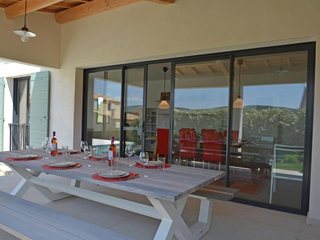 a dining table in a living room with glass walls at Superb villa with heated pool in Malauc ne in Malaucène