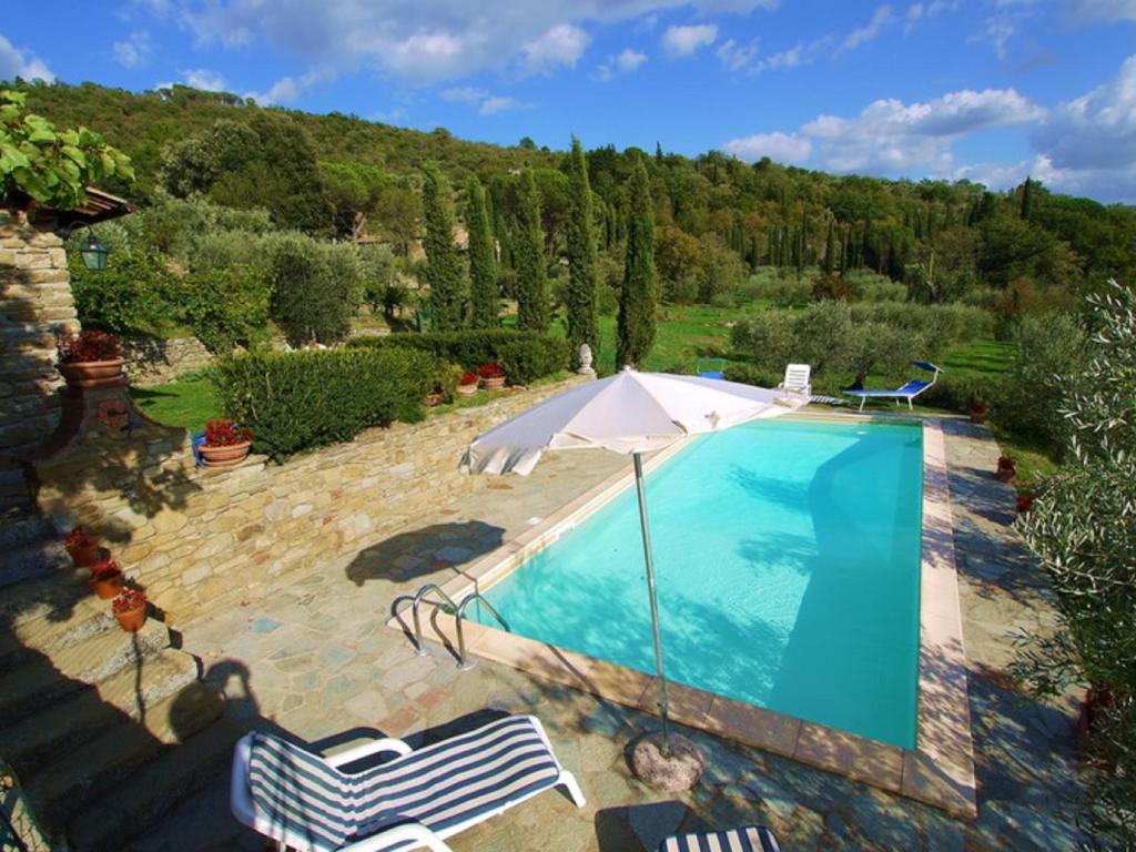 an overhead view of a swimming pool with an umbrella and chairs at Villa Eugenio in Cortona