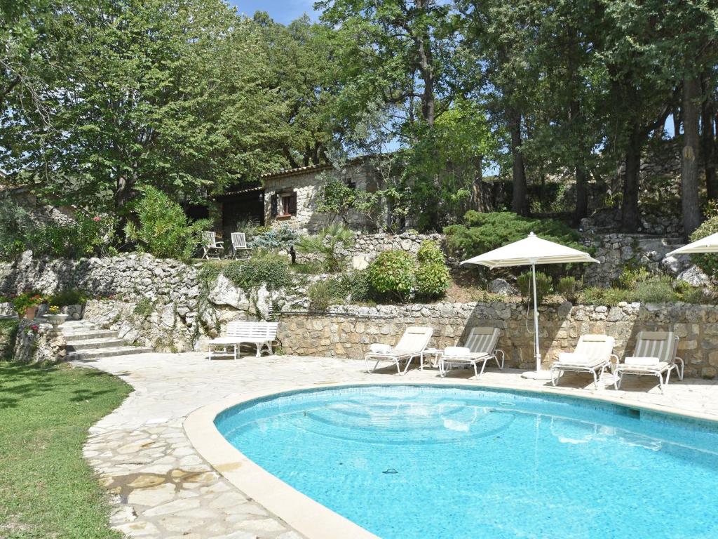 a swimming pool with chairs and an umbrella at Charming Villa in Callas with Private Swimming Pool in Callas