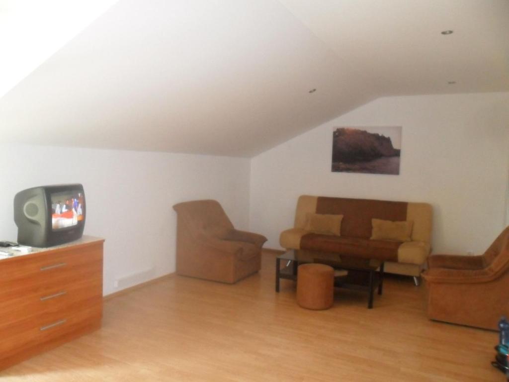 a living room with a couch and a tv at Attractive apartment in Dubrovni with balcony in Lopud