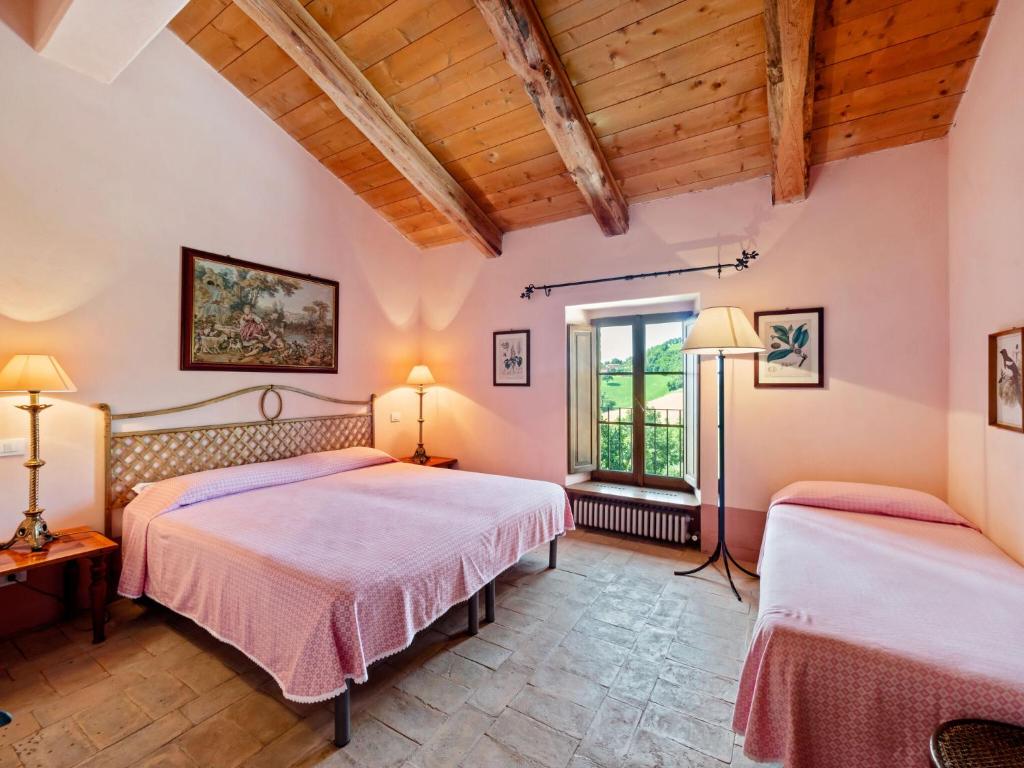 2 łóżka w pokoju z drewnianym sufitem w obiekcie Belvilla by OYO Locanda le Querce w mieście Frontino