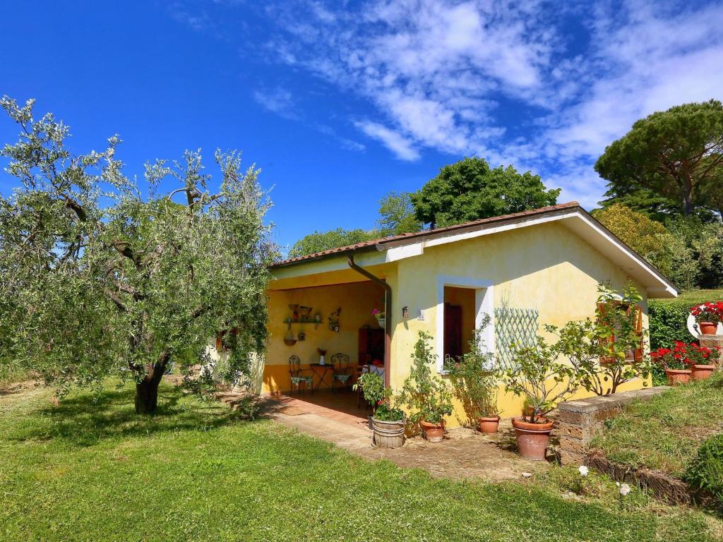 una pequeña casa amarilla con plantas en un patio en Belvilla by OYO Casaletto Graffi, en Civitella dʼAgliano