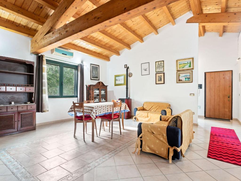 uma sala de estar com mesa e cadeiras em Belvilla by OYO Villa Manca em Santa Giusta