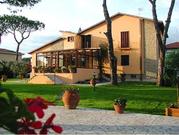 una grande casa con piante in vaso di fronte ad essa di B&B Villa Acero a Marina di Carrara