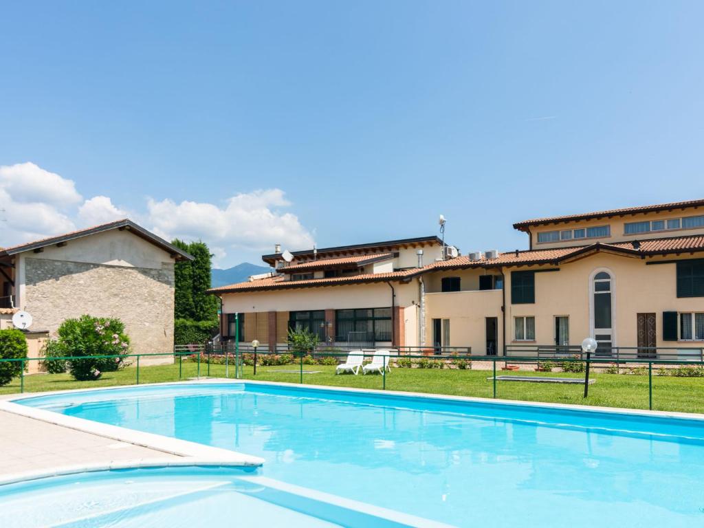 a large swimming pool in front of a building at Agriturismo with pool next 9 hole golf course and close to Sal and more in Salò