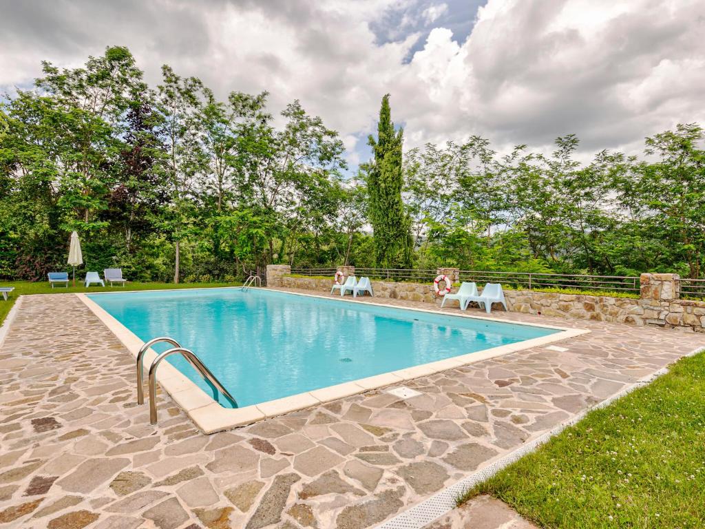 - une piscine avec deux chaises dans la cour dans l'établissement Belvilla by OYO Nimphaea, à Greve in Chianti