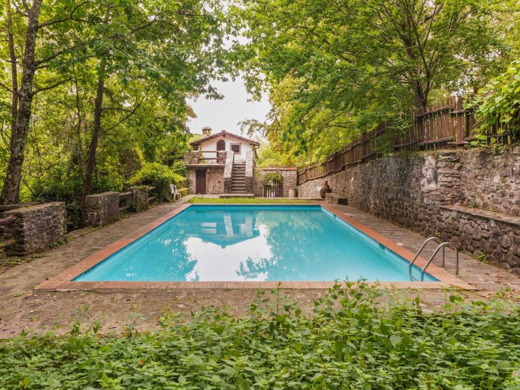 a swimming pool in front of a house at Belvilla by OYO Loggetta in San Marcello Pistoiese
