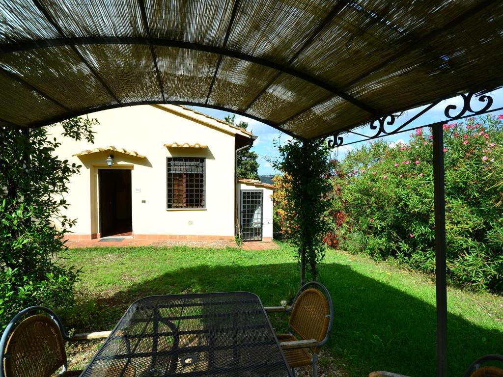 d'une terrasse avec une table et des chaises sous une pergola. dans l'établissement Cozy Home in San Casciano in Val di Pesa with BBQ, à San Casciano in Val di Pesa