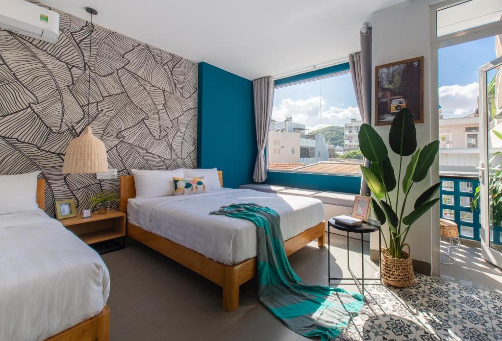 a bedroom with two beds and a large window at Shoho Hotel Nha Trang in Nha Trang