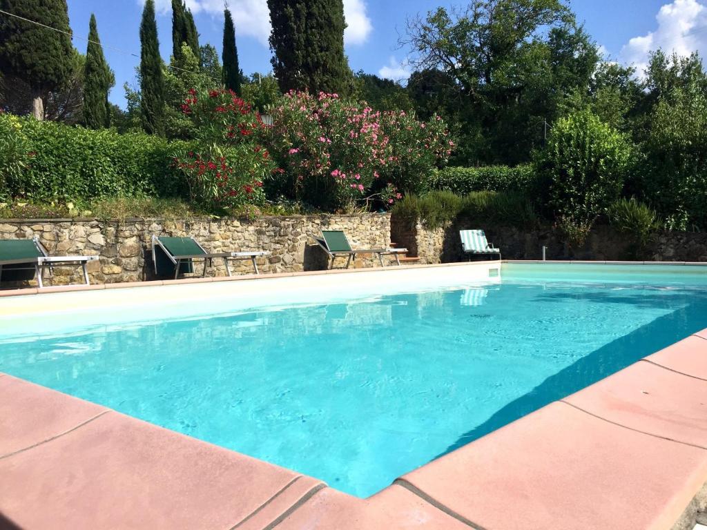 a swimming pool with blue water in a yard at Belvilla by OYO Il Fienile in Monterchi