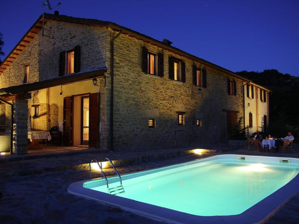 ModiglianaにあるPicturesque holiday home in Modigliana with shared poolの夜間の建物前のスイミングプール
