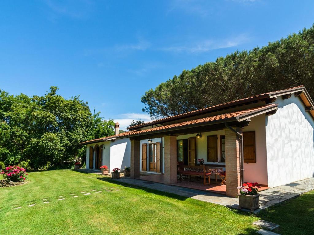 una pequeña casa con un patio de césped en Charm farmhouse with pool, en Castiglion Fiorentino